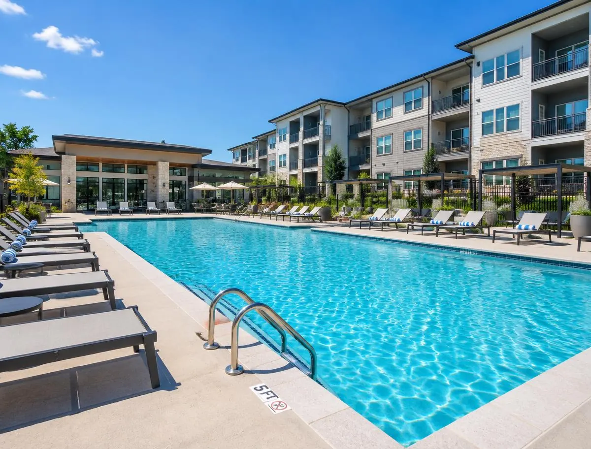 Commercial apartment community swimming pool with lounge chairs